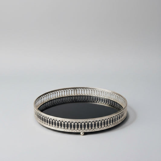 Round decorative tray with intricate border on a light gray background