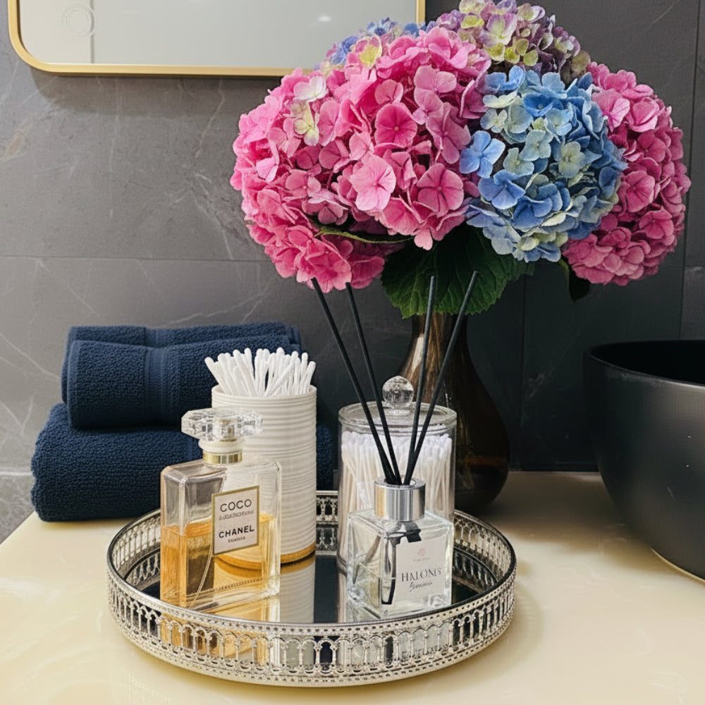 Decorative setup with flowers, towels, and perfume bottles on a tray.