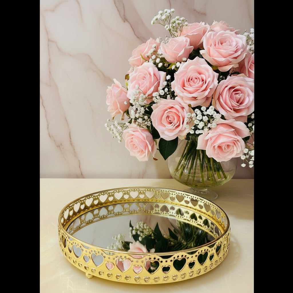 Decorative gold tray with heart designs on a surface with flowers.