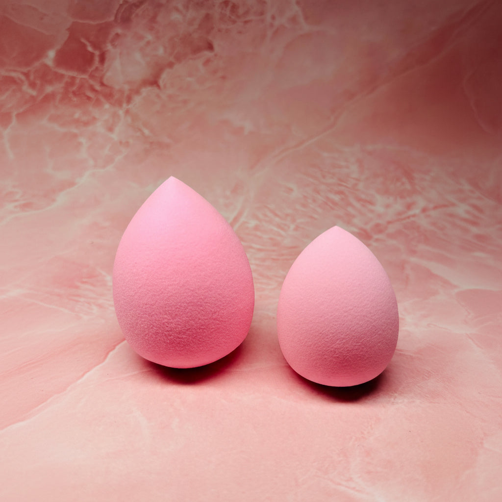 Two pink makeup sponges on a pink textured background